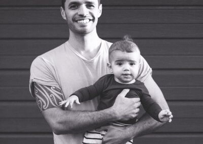 A father and his baby son in front of a panelled wall